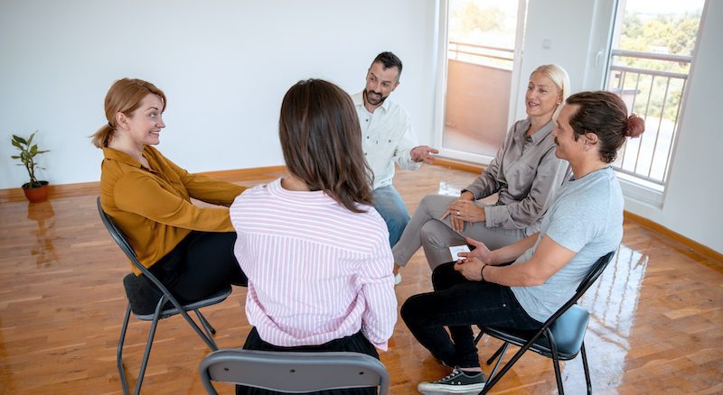 Benefits of Group Therapy Group of People sitting in the circle at Psychotherapy talking about their issues. Mental health concept